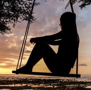 Silhouette of Woman on Swing during Golden Hour