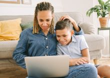 Woman and Young Boy Sitting on Floor with Laptop